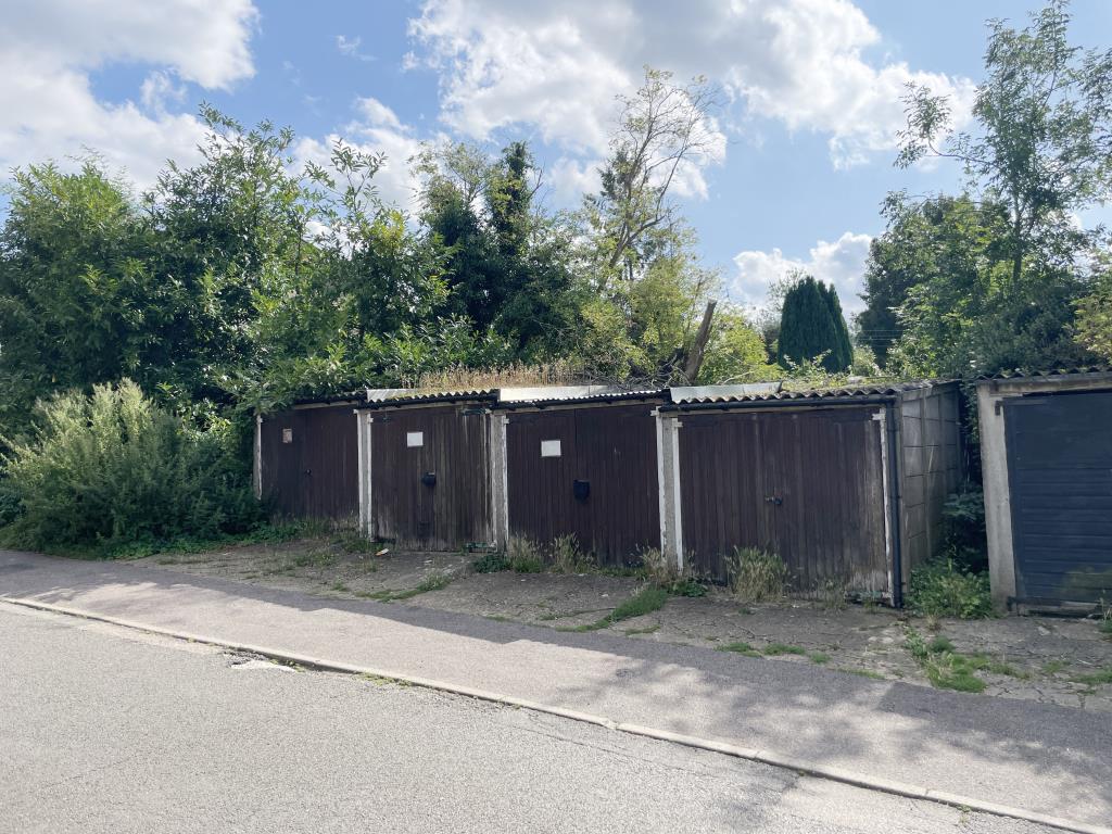 Lot: 74 - THREE VACANT LOCK-UP GARAGES - view of garages in Leeds village